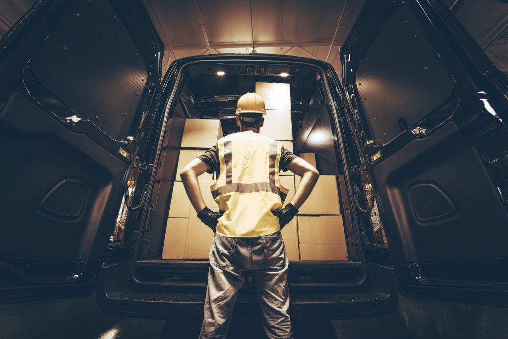 worker with safety gears inspecting the cargo van